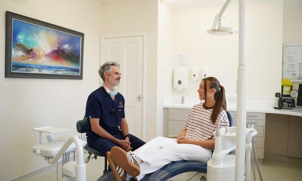 Dentist consulting with young female patient in dental office